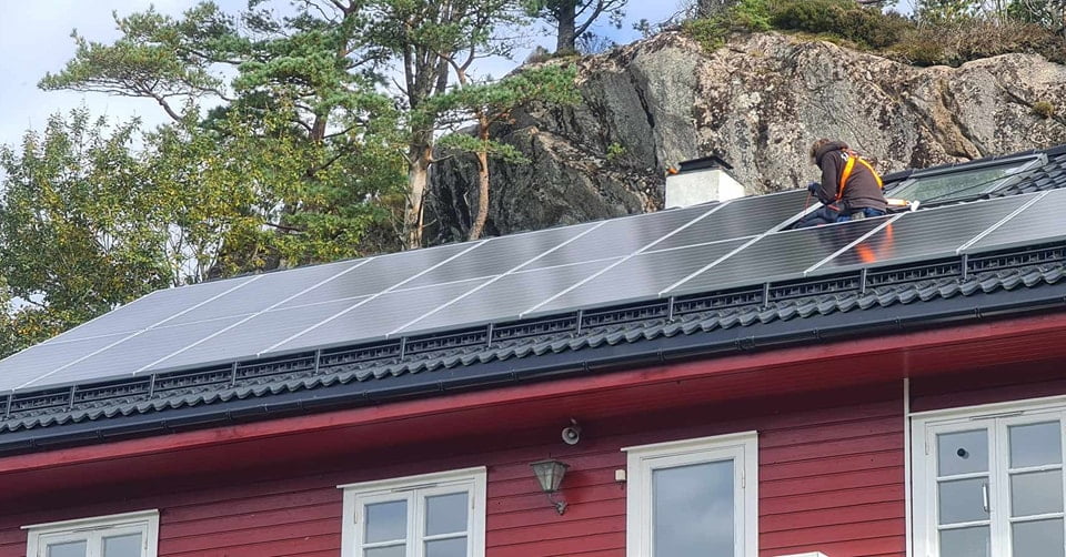 solceller på taket til et rødt hus i bergen